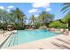 Community pool with palm trees, blue tile waterfall, and ample seating under a sunny, partly cloudy sky at 21320 N 56Th St # 2005, Phoenix, AZ 85054