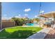 Backyard oasis with lush green grass, mature tropical landscaping, pool, and covered patio at 2640 S Terripin Cir, Mesa, AZ 85209