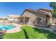 Large backyard featuring artificial turf, a pool, a covered patio, and ample lounge space at 2640 S Terripin Cir, Mesa, AZ 85209