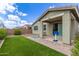 Green backyard with synthetic grass, covered patio, brick pavers, and a basketball hoop at 265 W Rainbow Bridge Ln, San Tan Valley, AZ 85140