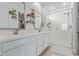 Bright bathroom featuring a double vanity, framed mirrors, decorative shelves, and glass enclosed shower at 265 W Rainbow Bridge Ln, San Tan Valley, AZ 85140