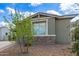 Inviting single-story home with stone accents and a lush green tree in the front yard at 265 W Rainbow Bridge Ln, San Tan Valley, AZ 85140