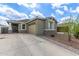 Beautiful home featuring a long driveway, tan garage door and desert landscaping at 265 W Rainbow Bridge Ln, San Tan Valley, AZ 85140