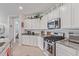 Well-lit kitchen with stainless steel appliances, granite countertops, and white cabinetry at 265 W Rainbow Bridge Ln, San Tan Valley, AZ 85140