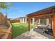 Backyard featuring a covered patio area with lounge chairs, string lights, and artificial grass at 27255 N 81St Ln, Peoria, AZ 85383