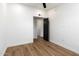 A bright bedroom featuring light wood floors and white walls with a stylish, modern black door at 280 S Evergreen Rd # 1336, Tempe, AZ 85288