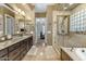 Bathroom featuring double sinks, granite counters, large framed mirror, shower and separate bathtub at 2876 E Cherrywood Pl, Chandler, AZ 85249