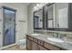 Bathroom with double sinks, granite counters, dark wood cabinets, and a door to the backyard at 2876 E Cherrywood Pl, Chandler, AZ 85249