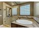 Modern bathroom featuring glass enclosed shower and standalone tub next to window with privacy glass blocks at 2876 E Cherrywood Pl, Chandler, AZ 85249