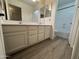 Bathroom with a dual sink vanity, decorative mirrors and hardware, and wood look flooring at 29900 N Maravilla Dr, San Tan Valley, AZ 85143