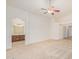 Bright bedroom offering neutral carpet, a ceiling fan, and arched entrance to the ensuite bathroom at 29900 N Maravilla Dr, San Tan Valley, AZ 85143