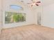 Spacious bedroom featuring a ceiling fan, a window with blinds, and an ensuite bathroom entry at 29900 N Maravilla Dr, San Tan Valley, AZ 85143