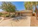 Inviting single-story home with mature trees, a wide driveway, and a tile roof at 29900 N Maravilla Dr, San Tan Valley, AZ 85143