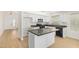 Well-lit kitchen featuring white cabinets, dark countertops, and an island at 29900 N Maravilla Dr, San Tan Valley, AZ 85143