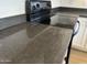 Close up of gray kitchen counter paired with black glass top stove and white cabinets at 29900 N Maravilla Dr, San Tan Valley, AZ 85143