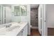 Bathroom with a double vanity and a glass shower with gray tiling and built-in shelving at 3110 E Desert Flower Ln, Phoenix, AZ 85048