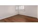 Compact bedroom featuring wood floors, white trim and walls, and a window with shutters at 3110 E Desert Flower Ln, Phoenix, AZ 85048