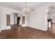 Open dining area with stone pillars, archways, and hardwood floors, adjacent to kitchen and stairway at 3110 E Desert Flower Ln, Phoenix, AZ 85048