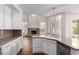 Stylish kitchen with white cabinets, granite countertops, flowing into a living area with stone fireplace at 3110 E Desert Flower Ln, Phoenix, AZ 85048