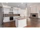 Modern kitchen with white cabinets, granite countertops, and a central island, flowing into the living area at 3110 E Desert Flower Ln, Phoenix, AZ 85048