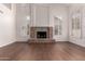 Open living room with a stone fireplace, high ceilings, and shuttered windows at 3110 E Desert Flower Ln, Phoenix, AZ 85048