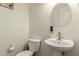 Modern half bathroom features a pedestal sink and toilet at 3126 W Apollo Rd, Phoenix, AZ 85041