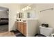 Well-lit bathroom featuring wood cabinetry, countertop space and a large mirror at 3126 W Apollo Rd, Phoenix, AZ 85041