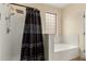 Bathroom area featuring a tub, shower with a glass block window allowing natural light at 3126 W Apollo Rd, Phoenix, AZ 85041