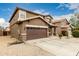 Side view of a two-story home with desert landscaping and a concrete driveway at 3126 W Apollo Rd, Phoenix, AZ 85041