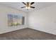 Bright, carpeted bedroom featuring a ceiling fan, a large window, and lots of natural light at 3236 E Chandler Blvd # 2057, Phoenix, AZ 85048