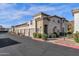 A beautiful two-story apartment exterior featuring individual garages, desert landscaping, and a neutral color palette at 3236 E Chandler Blvd # 2057, Phoenix, AZ 85048