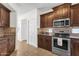 Well-lit kitchen with dark wood cabinets, stainless steel appliances, and decorative backsplash at 3236 E Chandler Blvd # 2057, Phoenix, AZ 85048