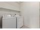 Bright laundry room with full sized washer and dryer set plus built in shelving for storage at 3363 W Lone Cactus Dr, Phoenix, AZ 85027