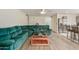 Open-concept living room with a green sofa, breakfast bar, and wood floors, perfect for entertaining at 3363 W Lone Cactus Dr, Phoenix, AZ 85027