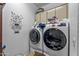 Laundry room featuring a modern washer and dryer set with overhead cabinets for storage at 3801 N 154Th Ln, Goodyear, AZ 85395