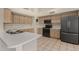 Well-lit kitchen with sleek, stainless steel appliances, tiled floors, and ample counter space at 4622 E Fairbrook Cir, Mesa, AZ 85205