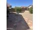 A serene backyard featuring mature trees, a patio, and gravel landscaping at 4728 E Swilling Rd, Phoenix, AZ 85050