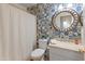 Charming bathroom with stylish blue and white patterned walls, a round mirror, and modern fixtures at 4728 E Swilling Rd, Phoenix, AZ 85050