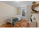 Bedroom with neutral paint, tiled flooring, arched window, desk and shelving at 4728 E Swilling Rd, Phoenix, AZ 85050