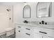 Bathroom features marble countertops, dual sinks, black fixtures, and a tiled shower at 5716 W Hazelwood St, Phoenix, AZ 85031