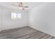 Bright bedroom featuring a ceiling fan, modern gray wood-look flooring, and a window at 5716 W Hazelwood St, Phoenix, AZ 85031