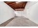 Spacious unfinished garage featuring exposed wood beams, white walls, and garage door at 5716 W Hazelwood St, Phoenix, AZ 85031