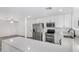 Beautiful kitchen with stainless steel appliances, quartz countertops, and gray wood-look floors at 5716 W Hazelwood St, Phoenix, AZ 85031