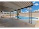 View of pool from covered patio, surrounded by decorative fencing and palm trees at 5716 W Hazelwood St, Phoenix, AZ 85031