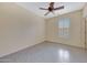 Bright bedroom features tile floors, a ceiling fan, and a window with plantation shutters at 6221 S 45Th Gln, Laveen, AZ 85339