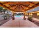 View from inside the covered cabana showcasing the pool, landscaping, and backyard at twilight at 6221 S 45Th Gln, Laveen, AZ 85339