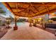 Backyard gazebo featuring ambient lighting, with view of pool, water feature and lush landscaping at dusk at 6221 S 45Th Gln, Laveen, AZ 85339