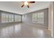 Open-concept living room with wood-look tile floors and large windows with shutter-style blinds at 6221 S 45Th Gln, Laveen, AZ 85339