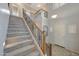 A staircase with carpeted stairs and a decorative wrought iron railing at 6221 S 45Th Gln, Laveen, AZ 85339