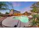 Backyard pool features a serene water feature, surrounded by lush greenery and a covered patio for outdoor enjoyment at 6221 S 45Th Gln, Laveen, AZ 85339